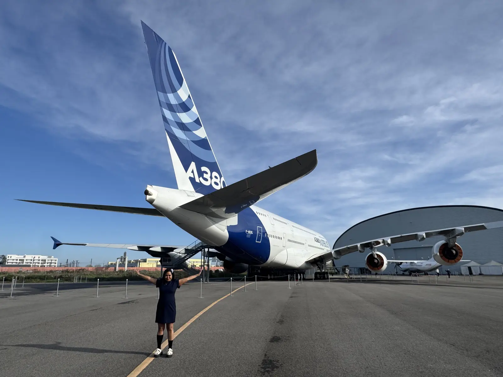Sarah standing beneath the tail of the first Airbus A380 built at the Toulouse aviation museum